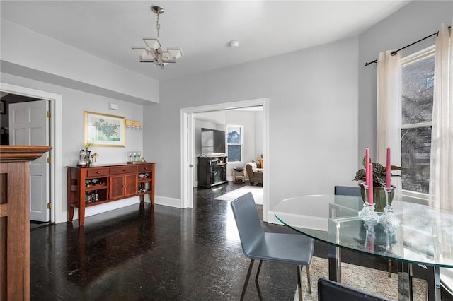 dining space with a notable chandelier and baseboards