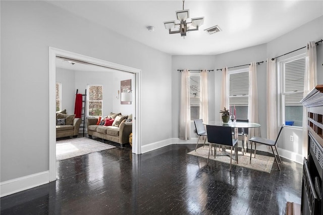 dining area featuring visible vents, baseboards, and wood finished floors