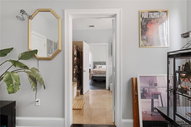 hallway featuring visible vents and baseboards