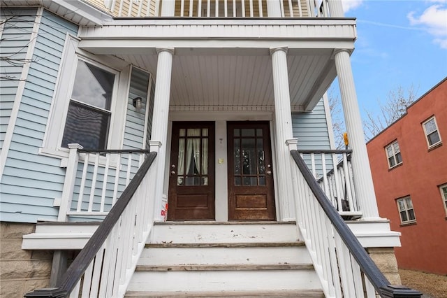 view of exterior entry featuring covered porch