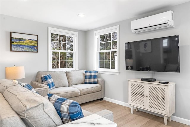 living room featuring light wood-style floors, baseboards, and a wall mounted AC