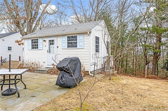 back of house with a patio area and roof with shingles