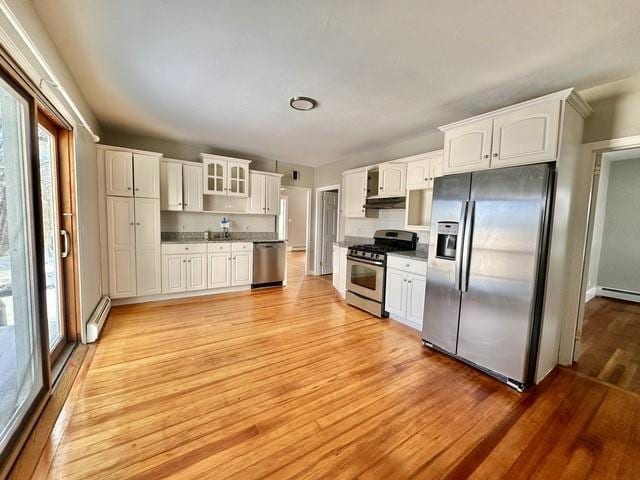 kitchen featuring stainless steel appliances, white cabinets, a baseboard heating unit, and light wood-style flooring