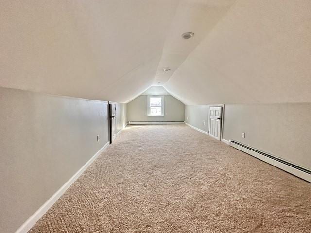 bonus room featuring carpet floors, a baseboard heating unit, vaulted ceiling, and baseboards