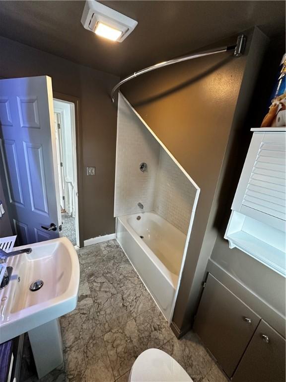 full bath featuring toilet, shower / bath combination, a sink, baseboards, and marble finish floor