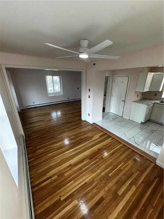 unfurnished living room with hardwood / wood-style flooring and a ceiling fan