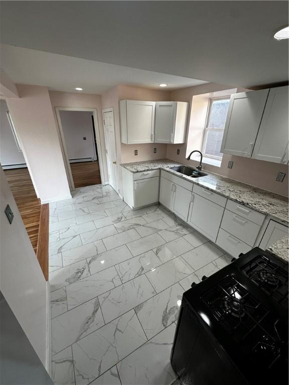 kitchen with recessed lighting, marble finish floor, a sink, and black gas range