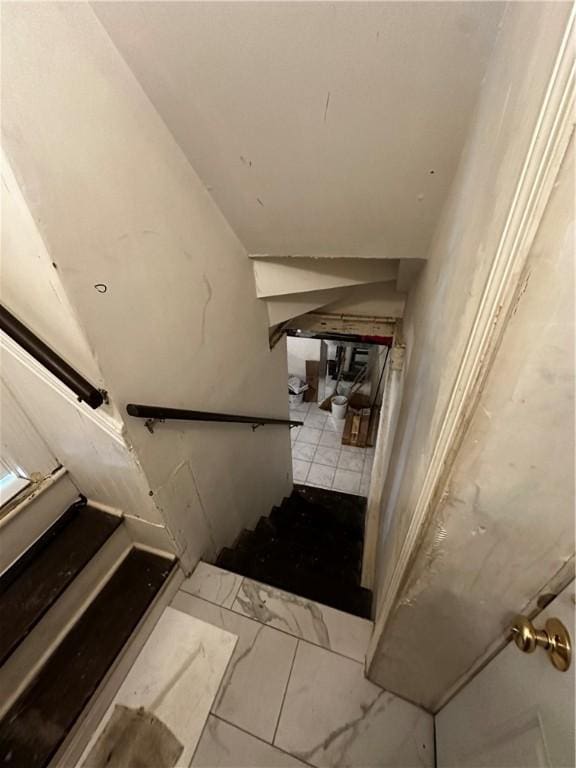 staircase with lofted ceiling and marble finish floor