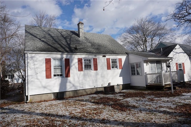 back of property with central AC, a chimney, a wooden deck, and roof with shingles