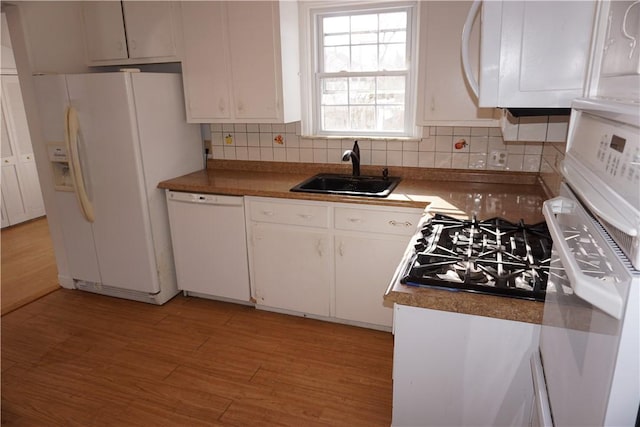 kitchen with light wood-type flooring, white appliances, white cabinetry, and a sink