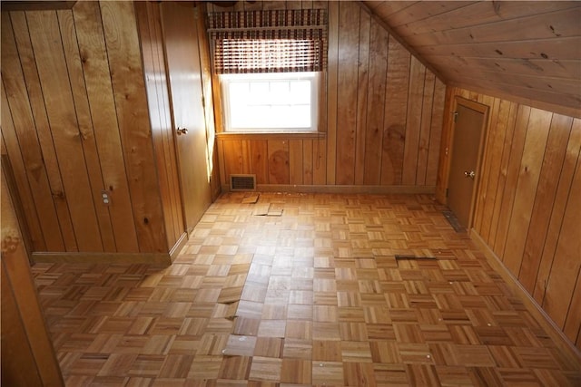 bonus room with visible vents, vaulted ceiling, and wooden walls