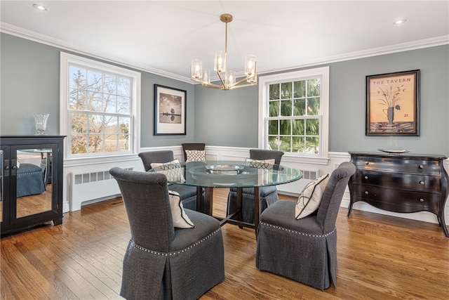 dining room with radiator heating unit, wainscoting, and ornamental molding