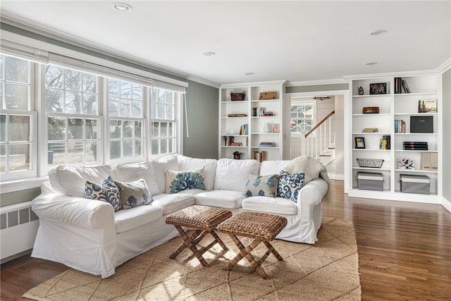 living room with stairway, crown molding, radiator heating unit, and wood finished floors