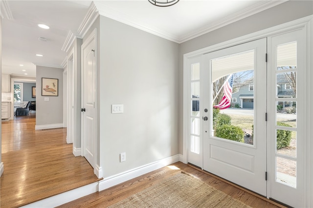 entryway with baseboards, light wood-style flooring, and crown molding