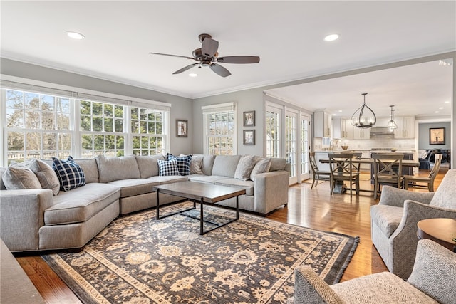 living room with crown molding, plenty of natural light, recessed lighting, and light wood finished floors