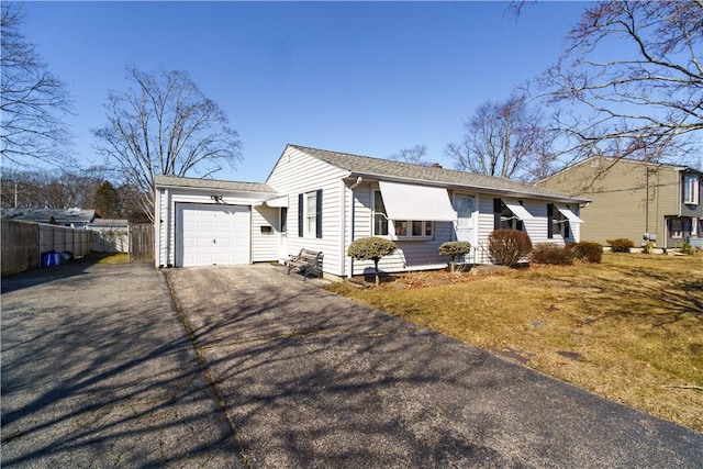 single story home featuring aphalt driveway, fence, and a garage