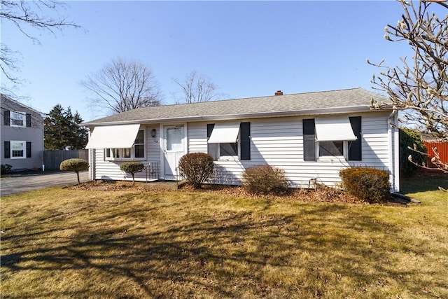 single story home with fence and a front lawn