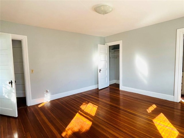 unfurnished bedroom featuring a closet, baseboards, and wood finished floors