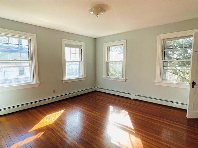 empty room featuring baseboard heating and wood-type flooring