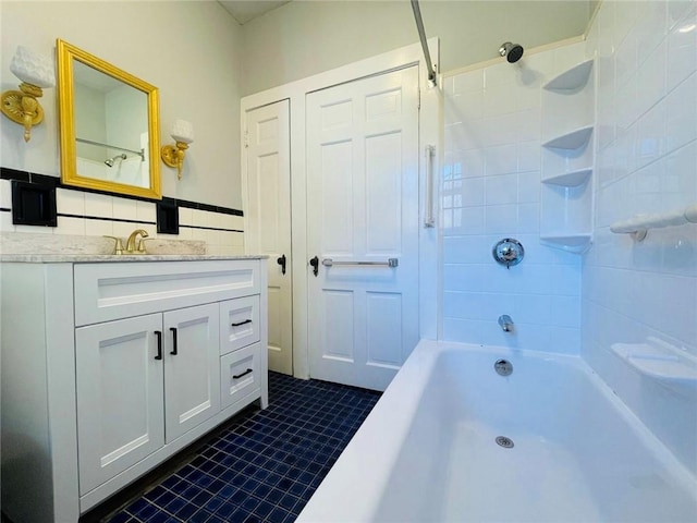 bathroom with tile patterned flooring, shower / bathing tub combination, tile walls, and vanity