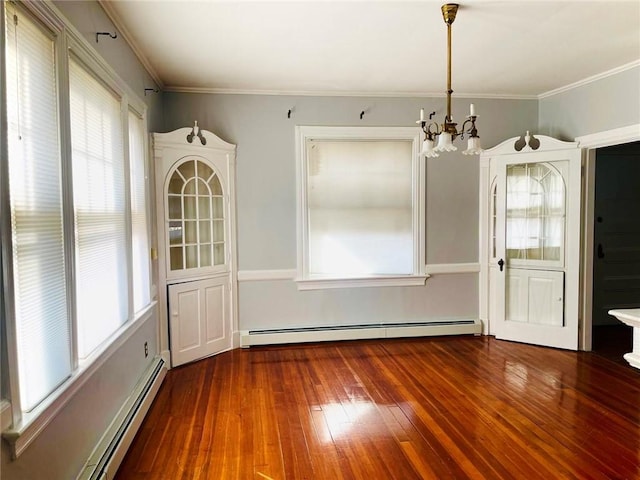 unfurnished dining area with a wealth of natural light, baseboard heating, hardwood / wood-style flooring, and an inviting chandelier