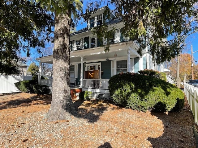 american foursquare style home with covered porch and fence