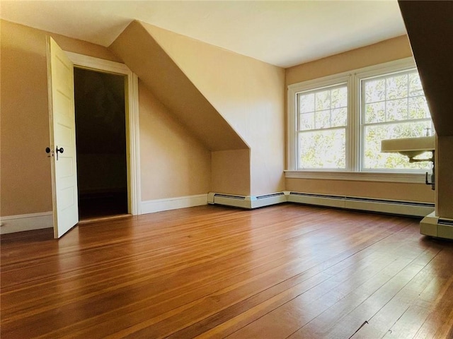 bonus room with baseboards, a baseboard heating unit, vaulted ceiling, and wood finished floors