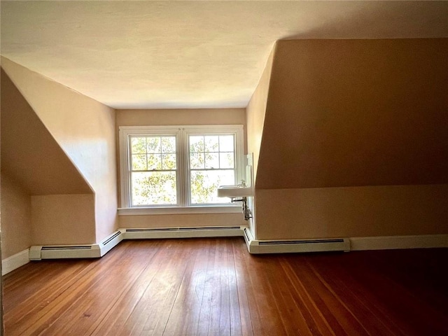 bonus room with baseboards and hardwood / wood-style floors