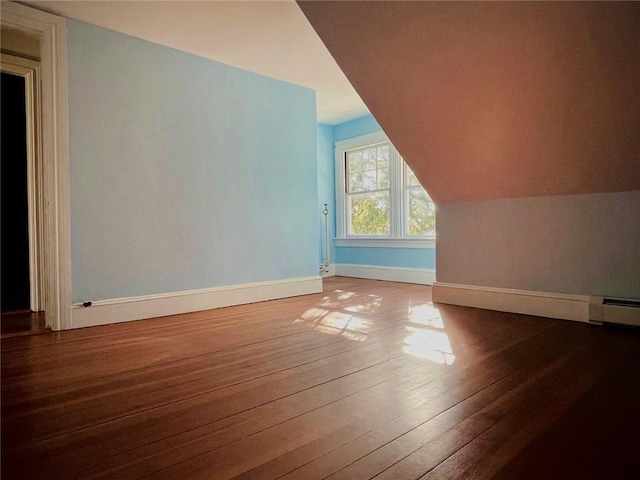 bonus room featuring lofted ceiling, baseboard heating, baseboards, and wood finished floors