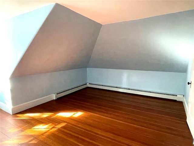 additional living space featuring vaulted ceiling, baseboards, and wood finished floors