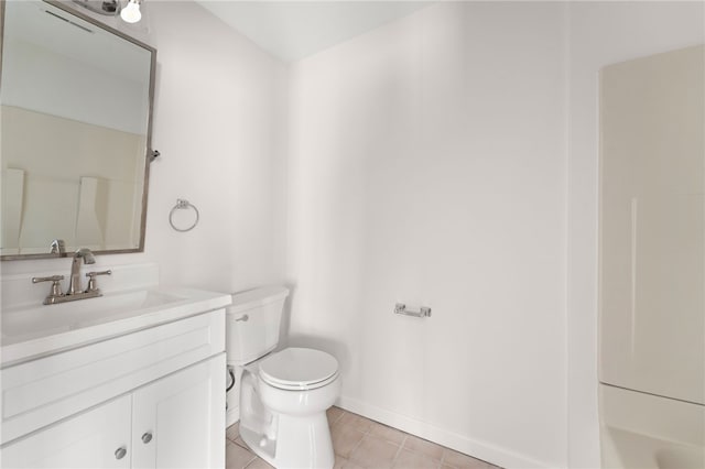 bathroom with tile patterned floors, toilet, vanity, baseboards, and walk in shower