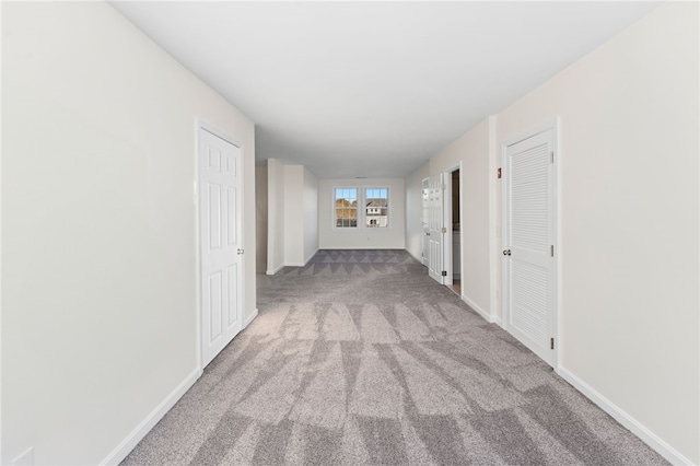 corridor with carpet and baseboards