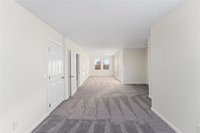 corridor with carpet and baseboards