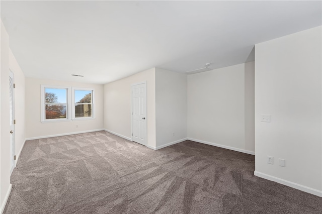 carpeted spare room with visible vents and baseboards