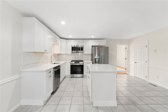 kitchen with light countertops, appliances with stainless steel finishes, a sink, and decorative backsplash