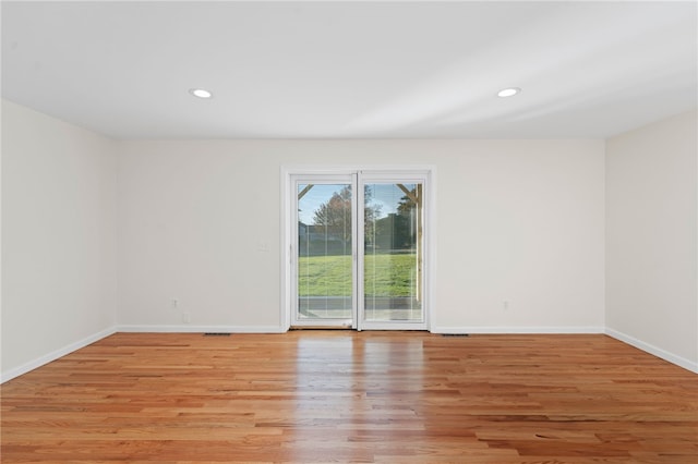 empty room featuring light wood finished floors, baseboards, and recessed lighting