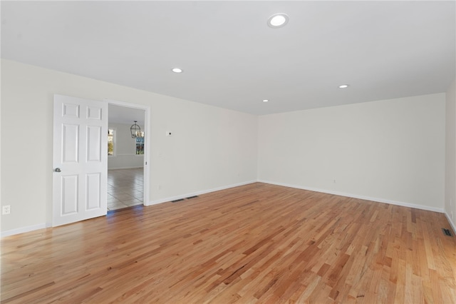 spare room featuring light wood-style floors, recessed lighting, and baseboards