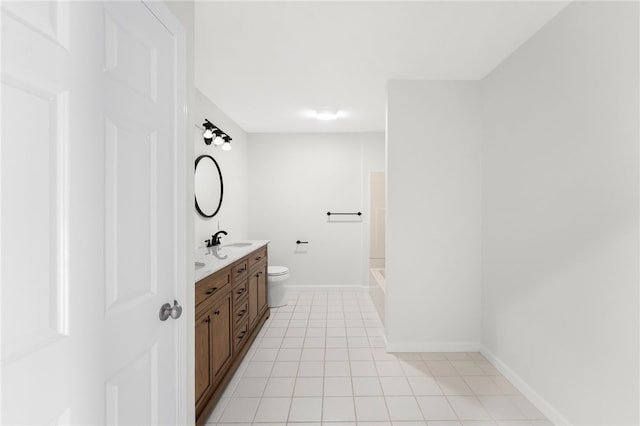 bathroom with baseboards, vanity, toilet, and tile patterned floors