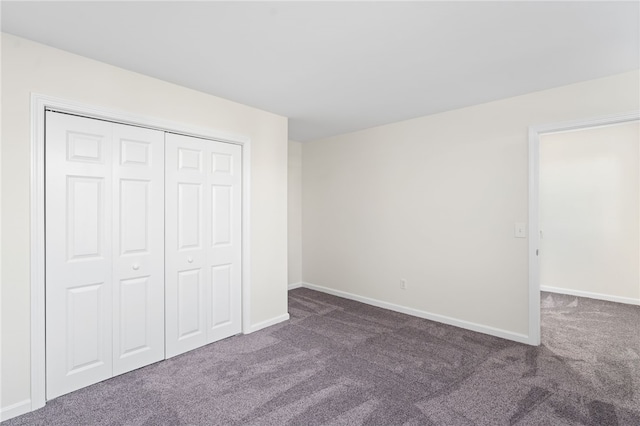 unfurnished bedroom featuring a closet, baseboards, and carpet flooring