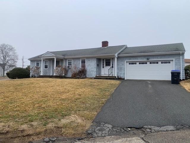 single story home featuring a garage, aphalt driveway, a front lawn, and a chimney