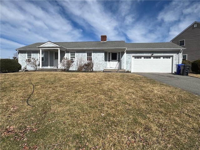 ranch-style home with a chimney, driveway, an attached garage, and a front yard