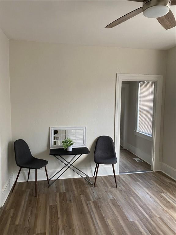 unfurnished room featuring baseboards, ceiling fan, visible vents, and wood finished floors