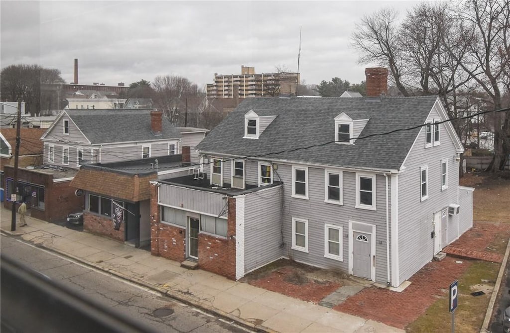 view of front of property featuring roof with shingles and a chimney