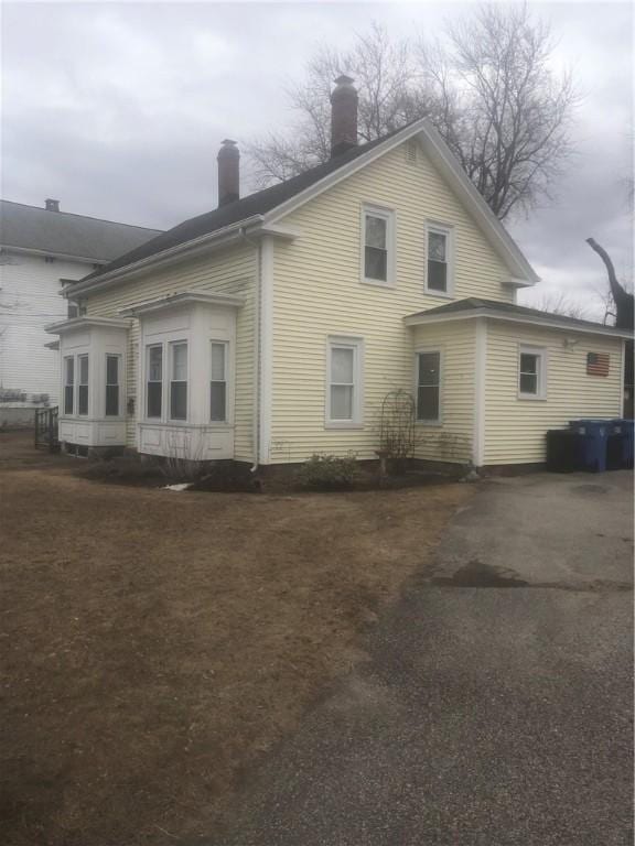 rear view of property featuring a chimney