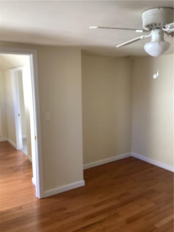 spare room with light wood-style floors, ceiling fan, and baseboards