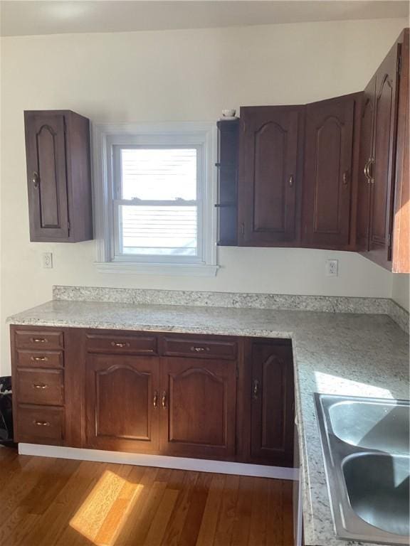 kitchen featuring light countertops, a sink, and dark wood finished floors