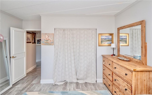 interior space with baseboards, light wood-type flooring, and crown molding