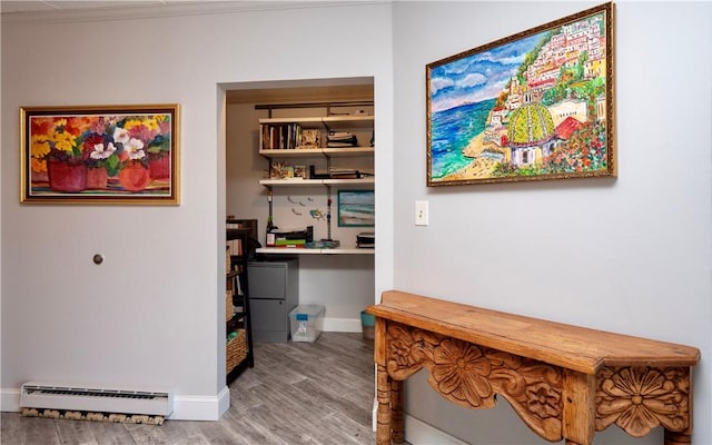 interior space featuring baseboard heating, wood finished floors, and baseboards