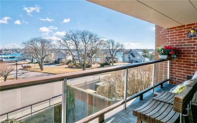 balcony featuring a residential view and a water view