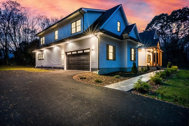 view of side of home with driveway and an attached garage